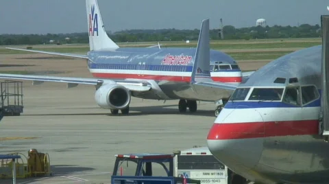 Pilots in cockpit prepare while second plane leaves gate. Stock Footage 133772