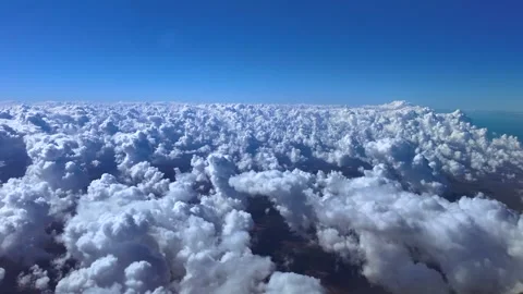 Pilot’s Eye in a Peceful Flight Over Cottony Clouds Hanging in a Blue Sky Over Stock Footage 323193192
