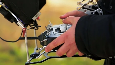 The pilot's hands on the control panel control the copter. Stock Footage 75863066