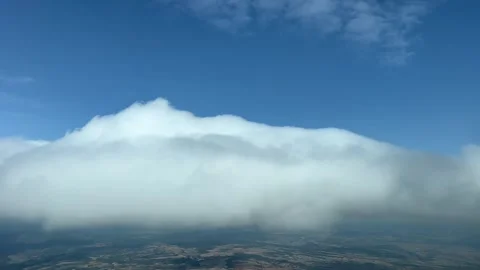 A pilot’s perspective while flying toward a tiny cumulus during a sunny Stock Footage 241882390