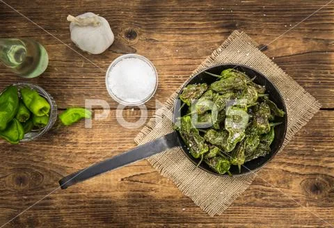 Pimientos de Padron on wooden background; selective focus Stock Photos