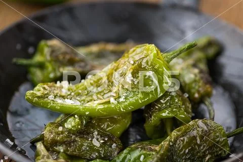 Pimientos de Padron on wooden background; selective focus Stock Photos
