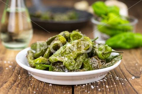 Pimientos de Padron on wooden background; selective focus Stock Photos