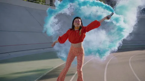 Pin-up lady riding retro roller with blue smoke bomb in hand Stock Footage 250609694