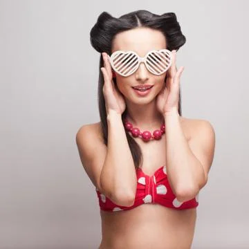 Pin up model in heart shaped sunglasses. red polka shorts and bra Stock Photos