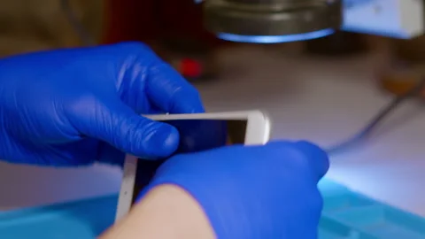 Pin the screen to a mobile device. The master fixes the phone Stock Footage 166922149