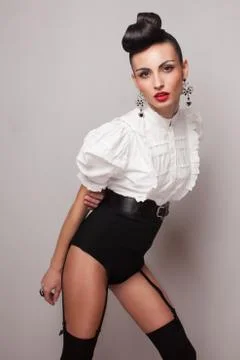 Pin up styling model posing in stocking, high shorts and white shirt. updo. Stock Photos