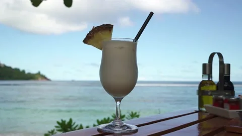 Pina colada cocktail close-up on the background of the ocean Stock Footage 154807475