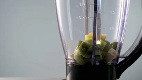 Pinapple chunks are thrown into blender to make smoothie. vegan drink for Stock Footage 170628650