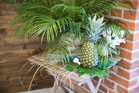 Pinapple on the table decorated with flowers Stock Photos