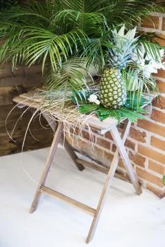 Pinapple on the table decorated with flowers Stockfoto's