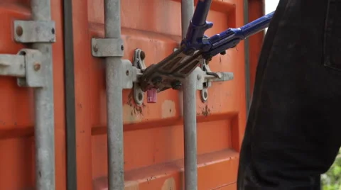 Pincer breaks the lock of a container, black hands N. Stock Footage 65758487