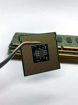 Pincers keeping a microprocessor CPU chip against a stack of RAM close-up iso Stock Photos