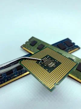 Pincers keeping a microprocessor CPU chip against a stack of RAM chips closeu Foto stock
