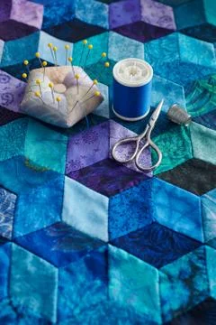 Pincushion, spool of thread, scissors and thimble on the tumbling blocks quil Stock-Fotos