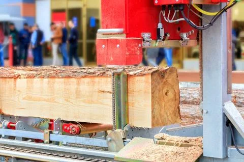 Pine boards are made from large logs at a modern automatic sawmill. Stock Photos