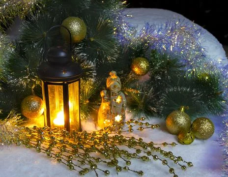 Pine branches and burning wax candles on the snow Stock Photos