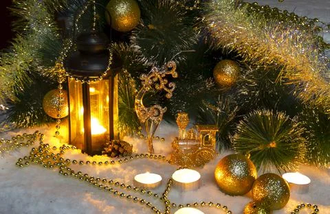 Pine branches and burning wax candles on the snow Stock Photos
