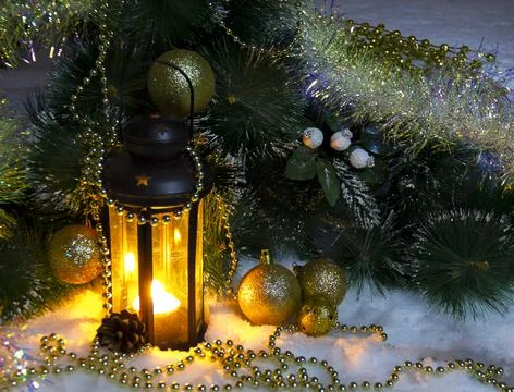 Pine branches and burning wax candles on the snow Stock Photos