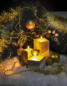 Pine branches and burning wax candles on the snow Foto stock