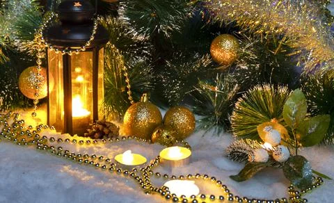 Pine branches and burning wax candles on the snow Stock Photos