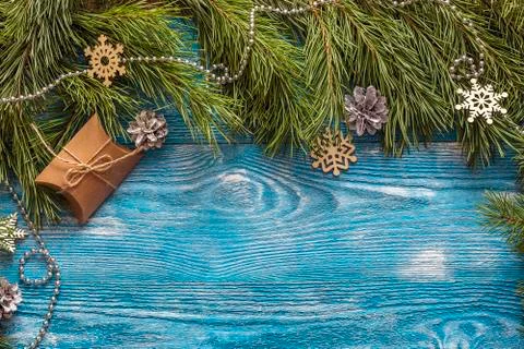 Pine branches and gift box on blue wooden background. Holidays background. Sp Stock Photos