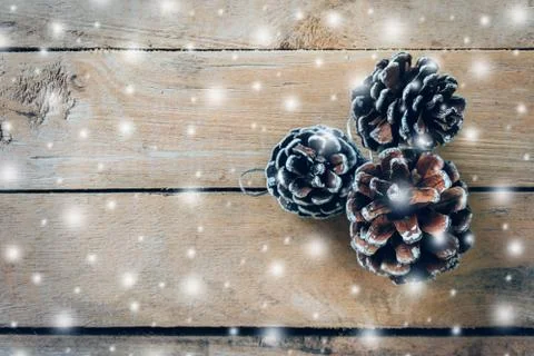 Pine cone and white snow on wood table background with space. Stock Photos
