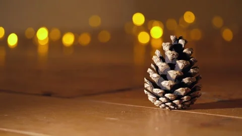 Pine cone in front of Christmas lights bokeh Stock Footage 292997568