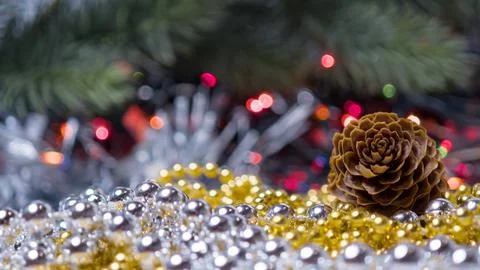 Pine Cone with Gold and Silver Beads on Colorful Holiday Lights Background Stock Photos