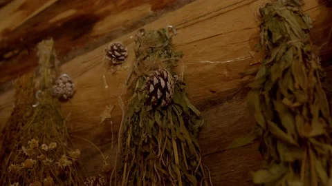 Pine cones adorn bouquets of aromatic herbs hanging in corner of vintage-style Stock Footage 221941823