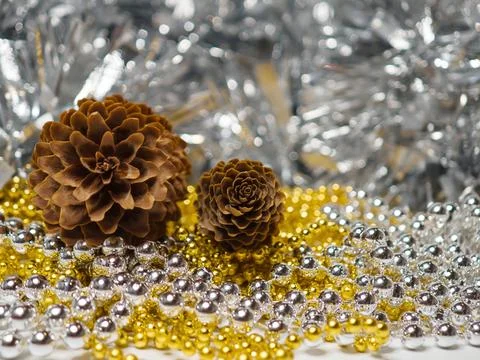 Pine Cones with Gold and Silver Beads on Sparkling Tinsel Holiday Background Stock Photos