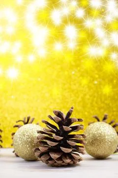 Pine cones with shiny balls on back yellow shiny background with stars Stock Photos