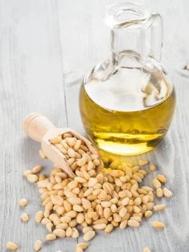 Pine nut oil and pine nuts on gray wooden background Stock Photos