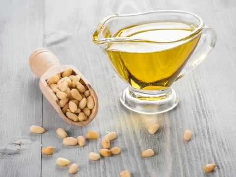 Pine nut oil and pine nuts on gray wooden background Stock Photos