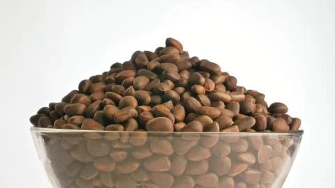 Pine nut rotate are on a table in a plate. Snack in transparent dish on an Stock Photos