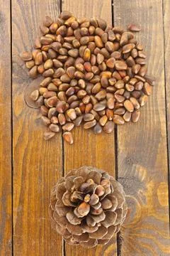 Pine nuts and pine cone on wooden table Stock Photos