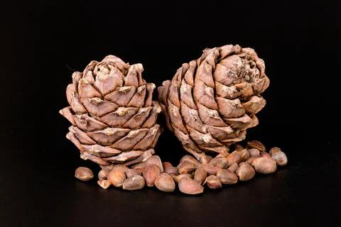 Pine nuts and ripe pine cones on a black background Foto stock