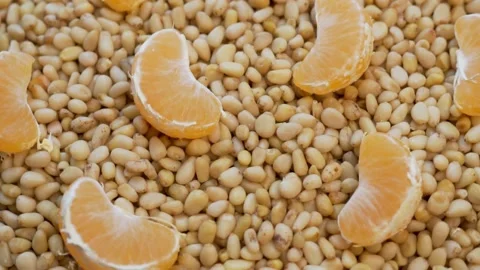 Pine Nuts and Slices of Tangerines Citrus Fruits, Close-up, Rotation, Top View.  Stock Footage 142874345