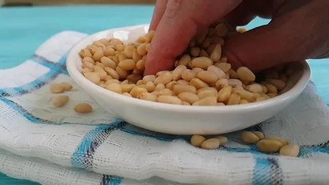 Pine nuts on a blue wooden hand background Video stock 87171836