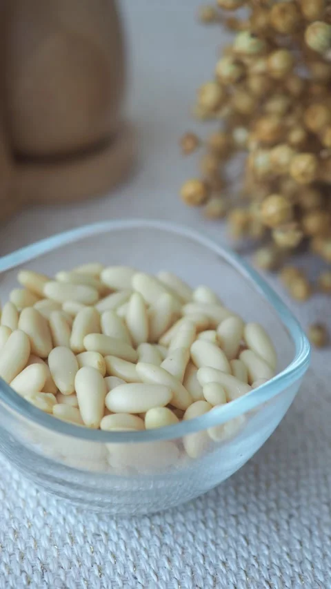 Pine nuts in a bowl on a table with dried flowers Stock Footage 326180985