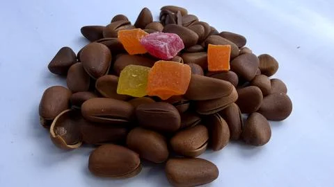 Pine nuts with candied fruit pieces on white background for food design Stock Photos