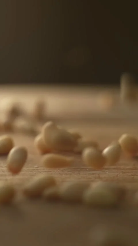 Pine nuts falling on a wooden table in slow motion Stock Footage 333398400