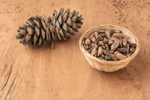 Pine nuts, kernels and cone on a wooden table Foto stock