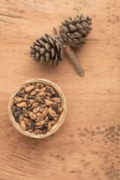 Pine nuts, kernels and cone on wooden table Foto stock