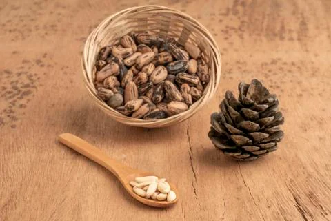 Pine nuts, kernels and cone on wooden table Foto stock