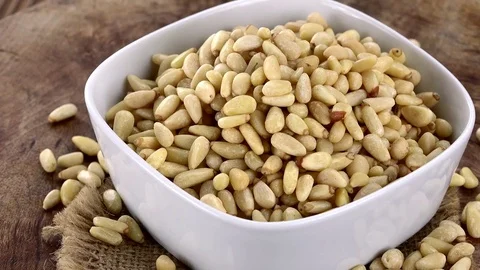 Pine Nuts (rotating on a wooden plate; seamless loopable; 4K) Stock Footage 78709407