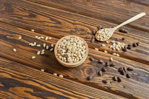 Pine nuts on a wooden table Stock Photos