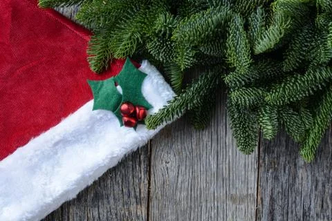Pine tree branches and santa hat on rustic wood background Stock Photos