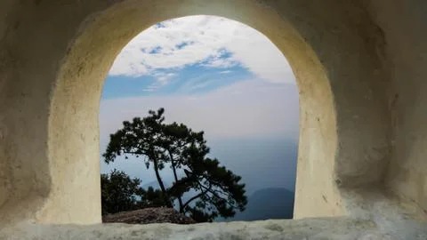 The pine tree on the cliff look through a tunnel  on blue sky background Stock Photos