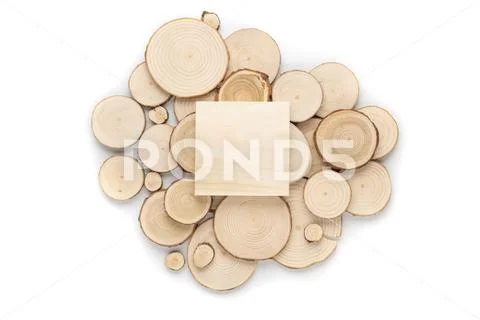 Pine tree cross-sections with annual rings and wooden square on white background Stock Photos